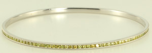 Yellow diamonds stand out on this 14 karat white gold diamond bangle bracelet