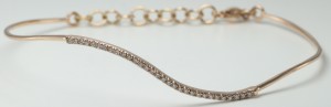A 14 karat rose gold wave diamond wire bracelet