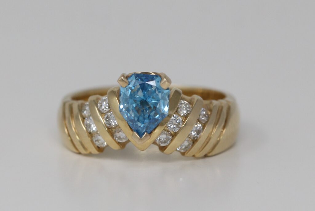 18k Yellow Gold Pear & Round diamond shape engagement ring with set shoulders(0.75 ct, Blue(Treated), I1)